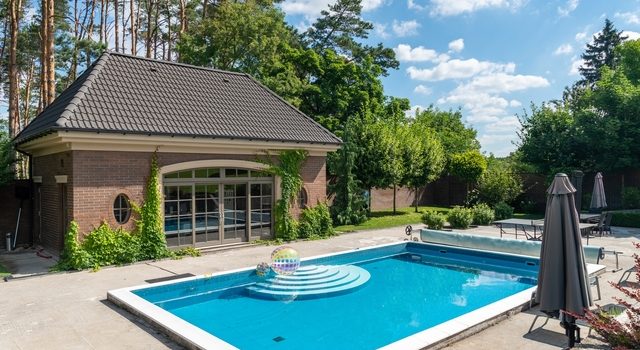 Piscine coque rectangulaire avec terrasse moderne dans un jardin ensoleillé près de Montpellier